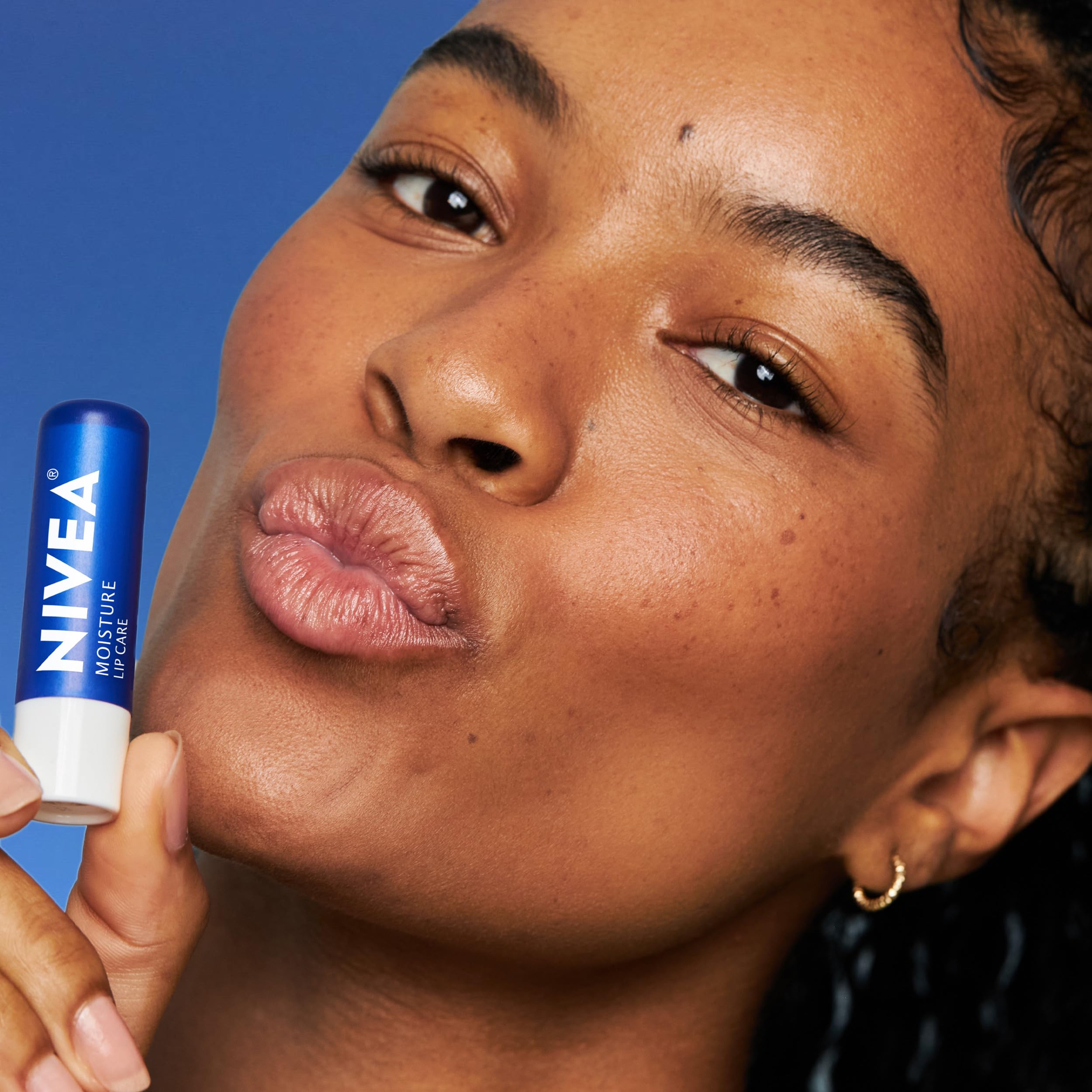 NIVEA applying lip balm outdoors in winter protecting lips from cold