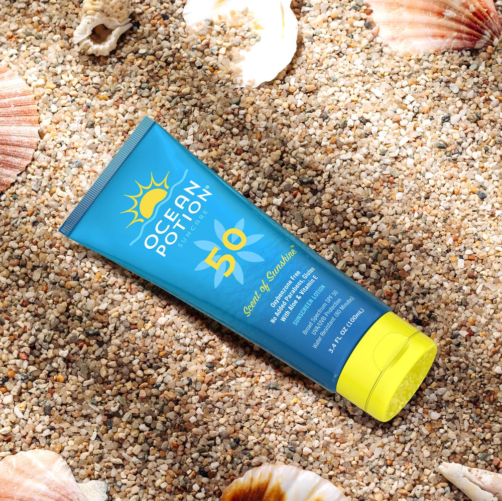 Ocean Potion bottle beside sunglasses showing compact travel-friendly size