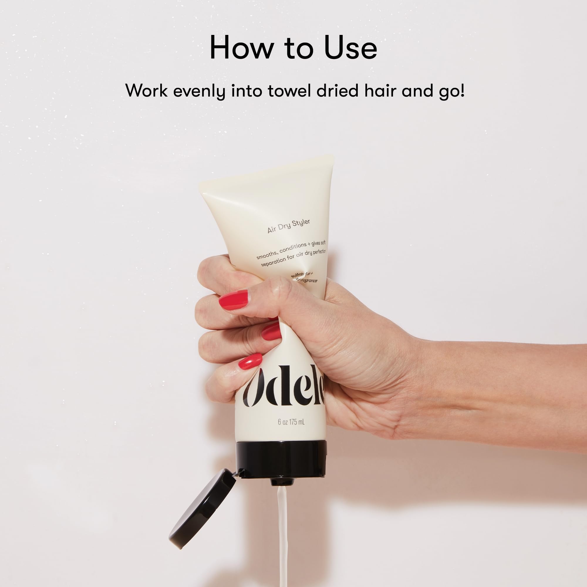 Stylist applying Odele on damp wavy hair to reduce frizz and define waves