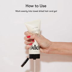 Stylist applying Odele on damp wavy hair to reduce frizz and define waves