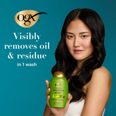 OGX bottle held next to hand to display 13 fl oz size and portability benefit