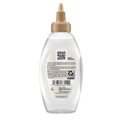 OGX bottle staged on bathroom shelf, suggesting routine-ready treatment