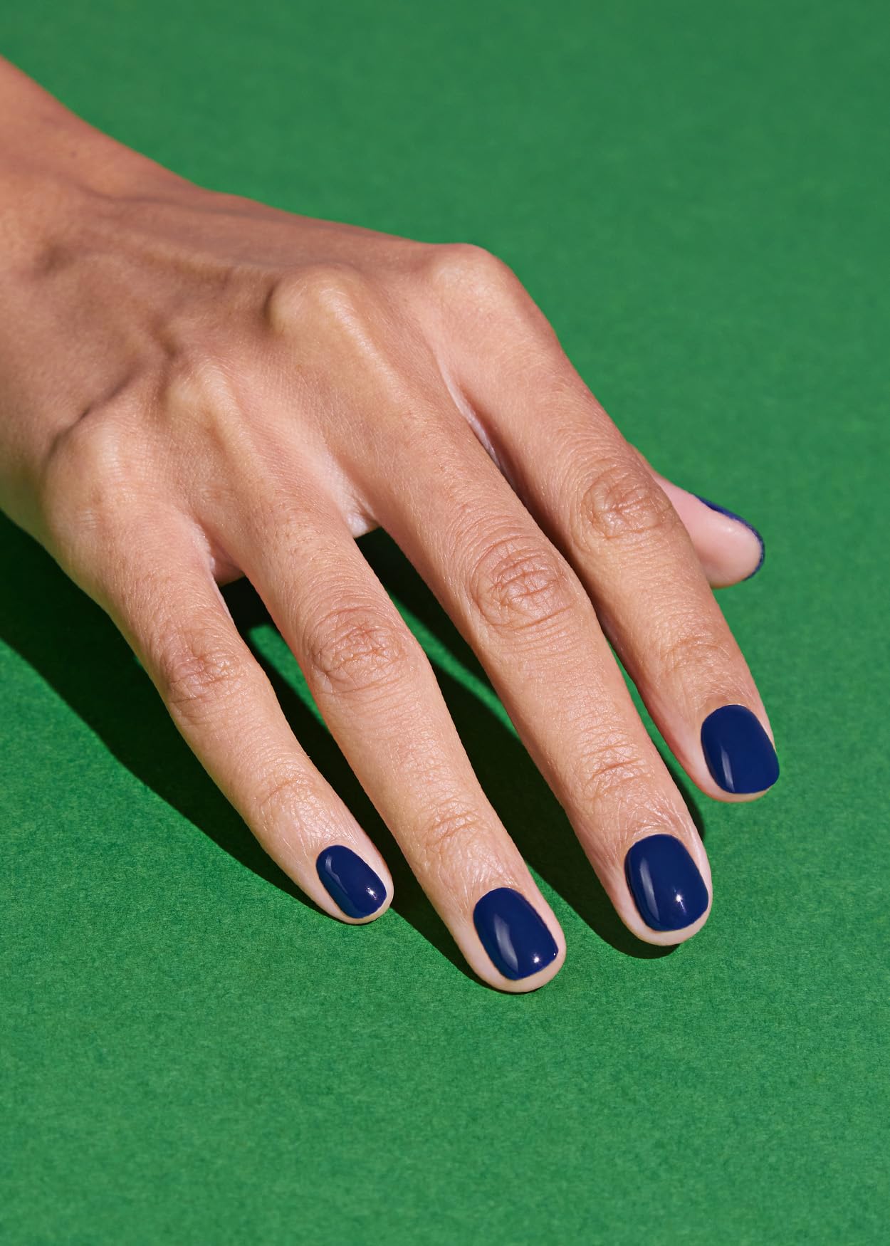 ohora model wearing N Royal Navy strips showing polished navy manicure benefit