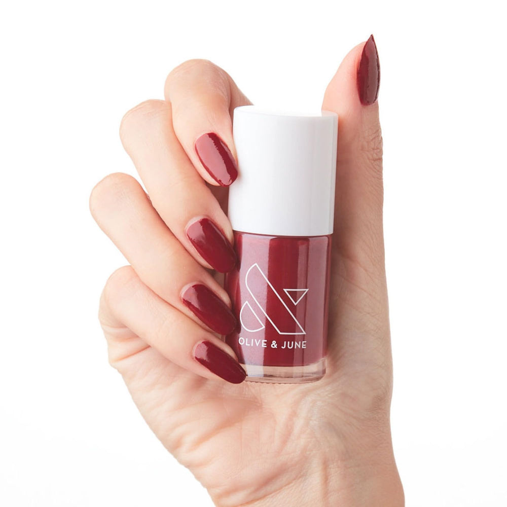 Olive & June bottle front view showing Cozy Up Brick Red shade and benefits