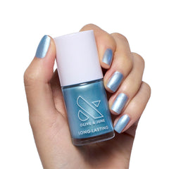 Olive & June bottle front view showing shimmery blue polish and glossy appeal