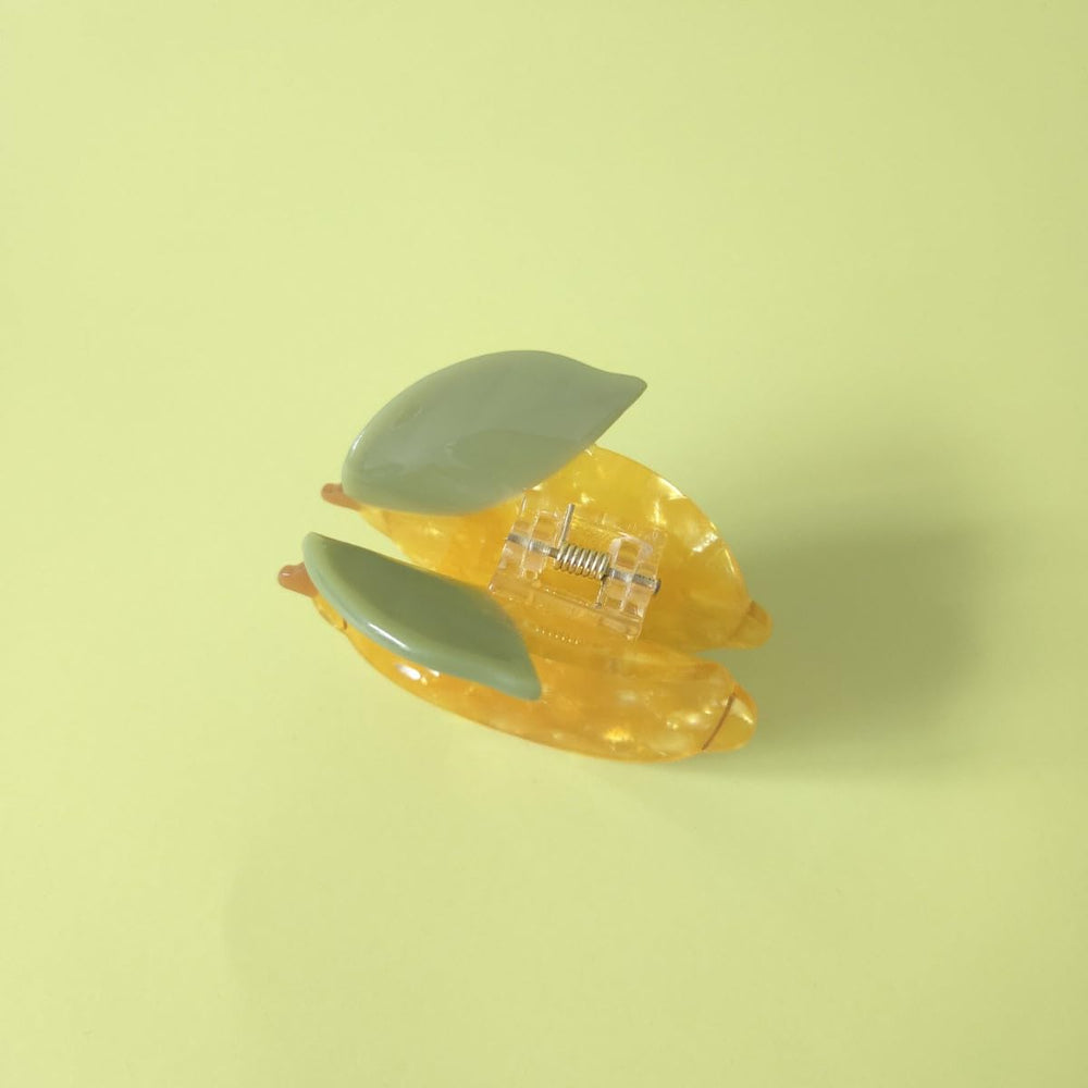 OMG Decor lemon claw clip clipped to a bag strap doubling as chic accessory