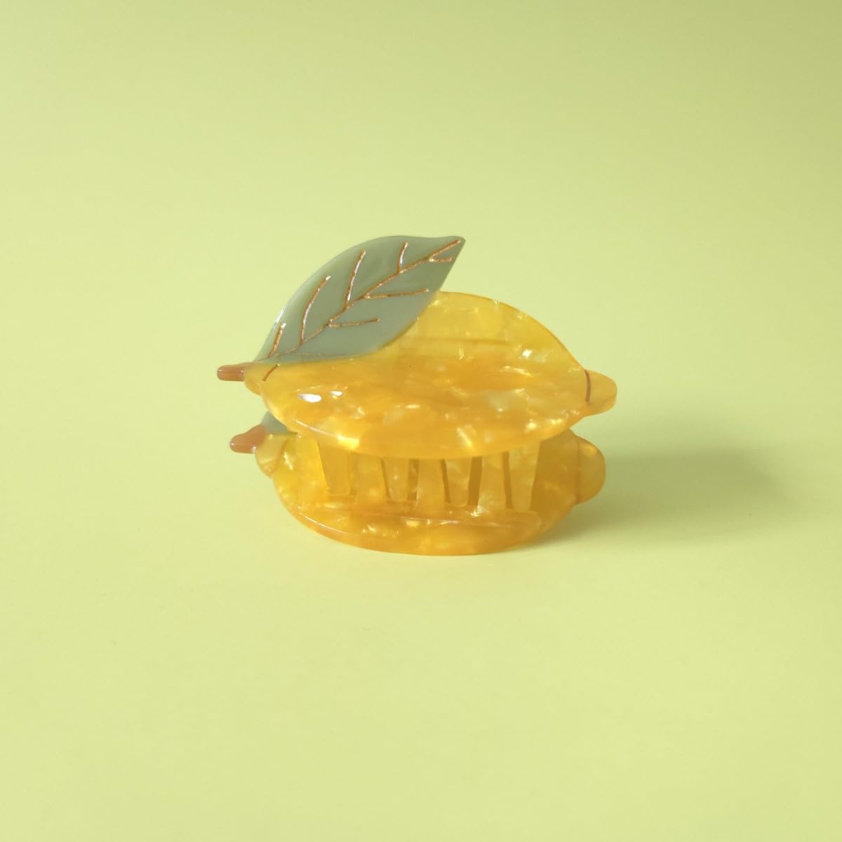 OMG Decor lemon claw clip next to a coin for scale showing compact, travel-friendly size
