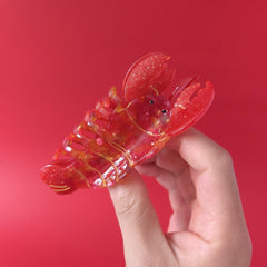 OMG Decor clip held in hand for scale to show compact, travel-friendly size