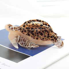 OMG Decor size comparison in hand showing compact clip size for travel convenience