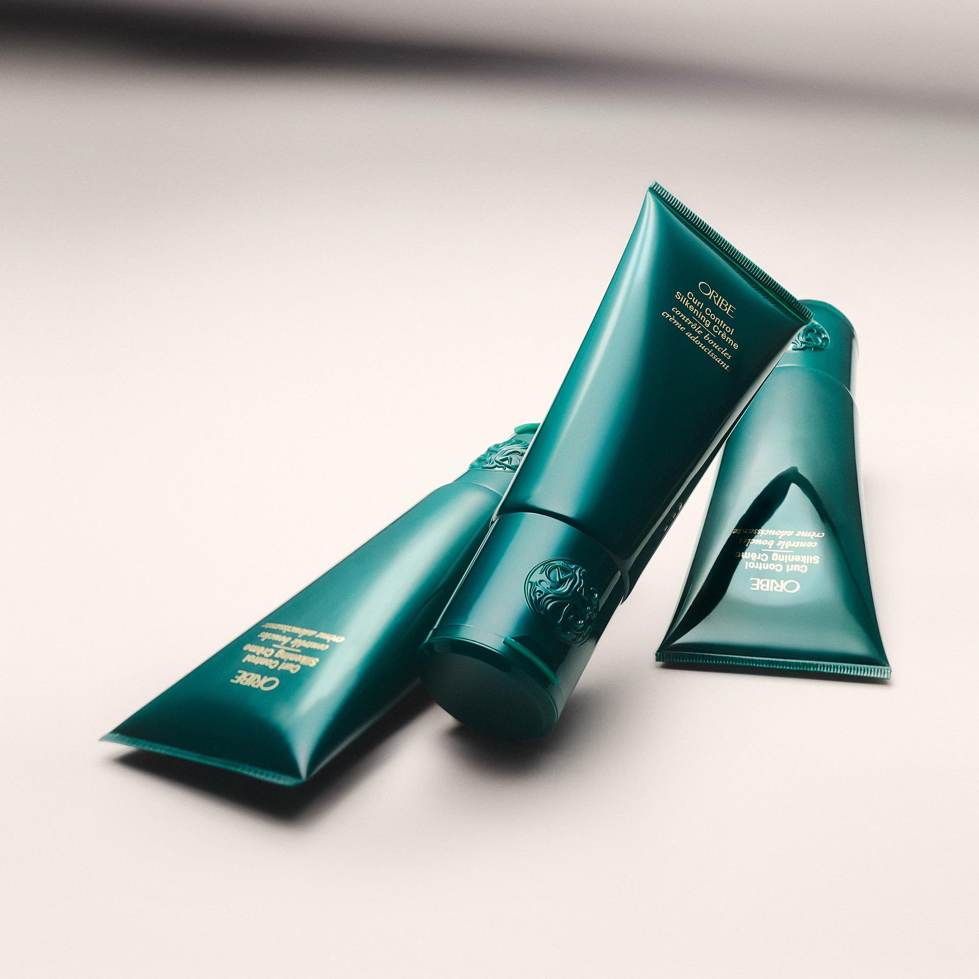 Oribe Curl Control cream spread on fingers highlights smooth application benefit