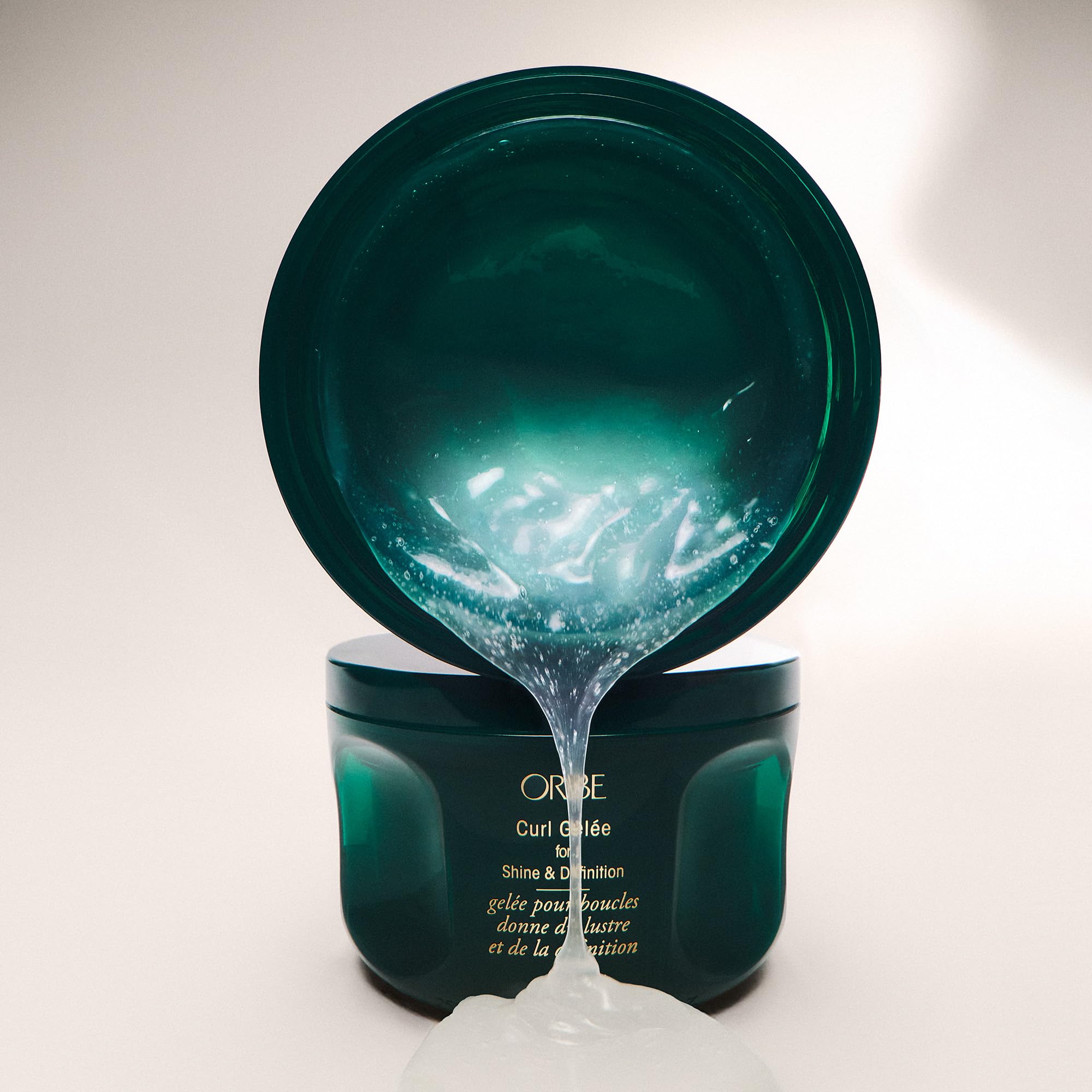 Oribe curl gel on hair being diffused showing voluminous, high-shine results benefit