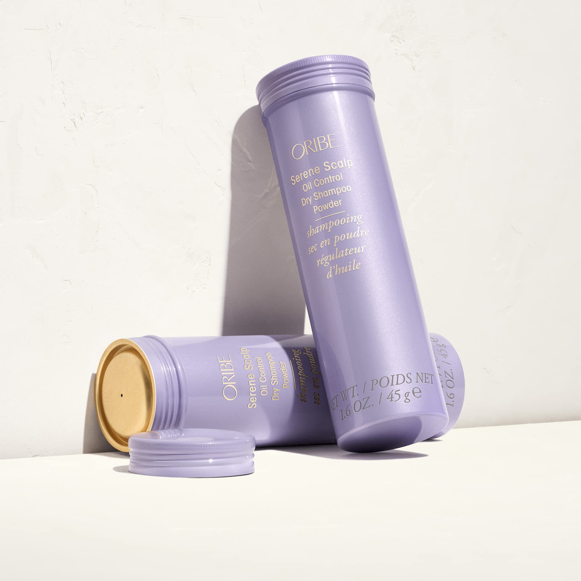ORIBE bottle beside a coin showing compact travel size and convenient portability