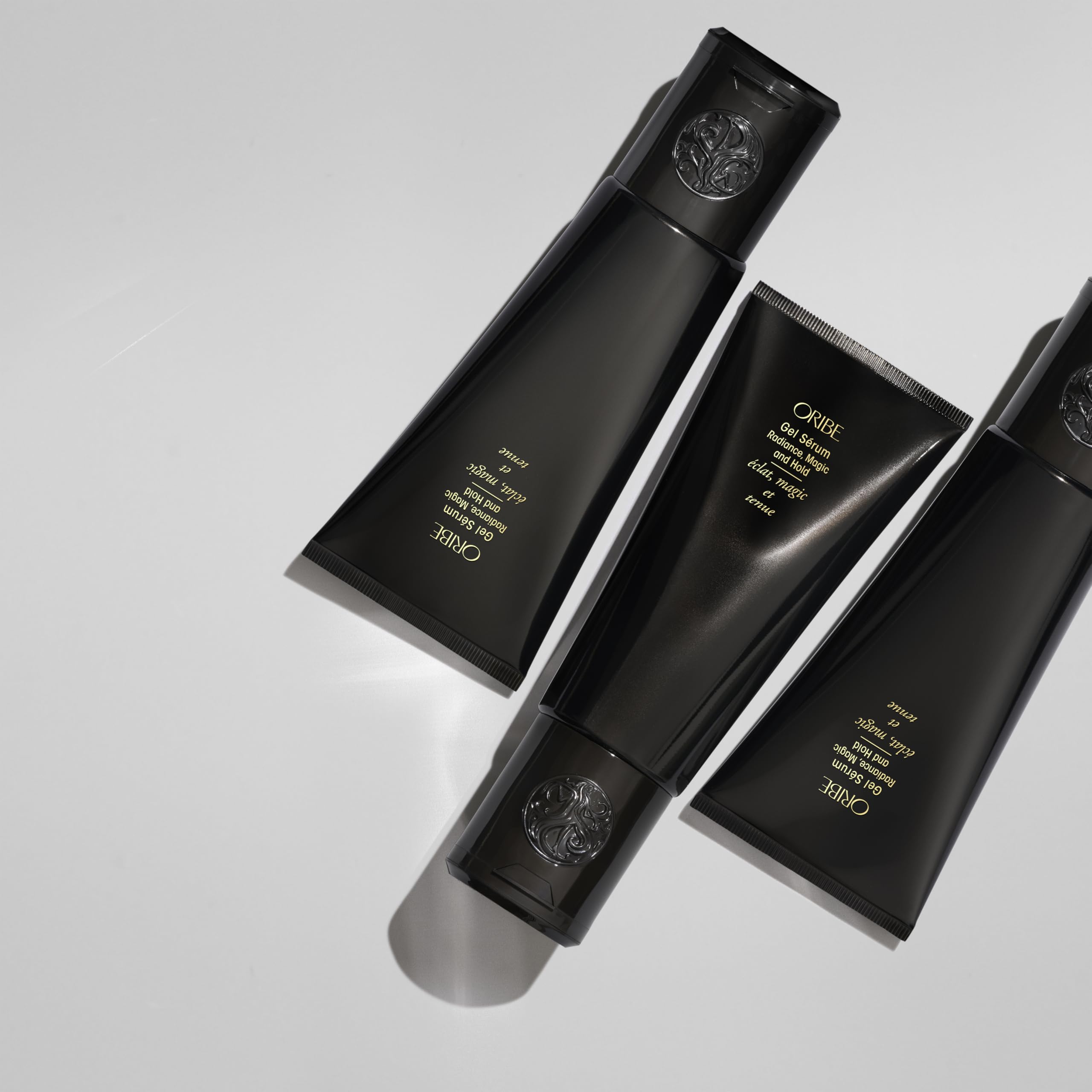 Oribe bottle in hand for size perspective and easy daily use