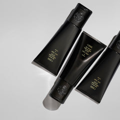 Oribe bottle in hand for size perspective and easy daily use