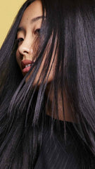 Oribe Hair Alchemy shampoo in shower setting demonstrating salon-quality use