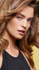 Oribe Hair Alchemy bottle held in hand showing scale and travel-friendly size