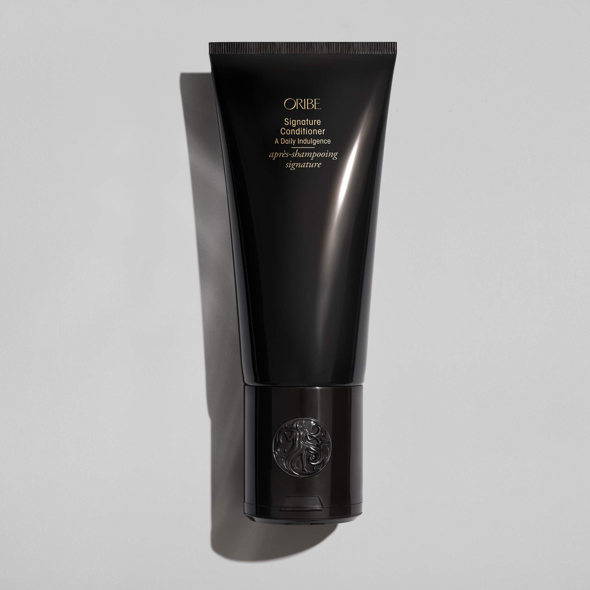 Oribe signature conditioner creamy texture shown on hand for hydrating lightweight feel