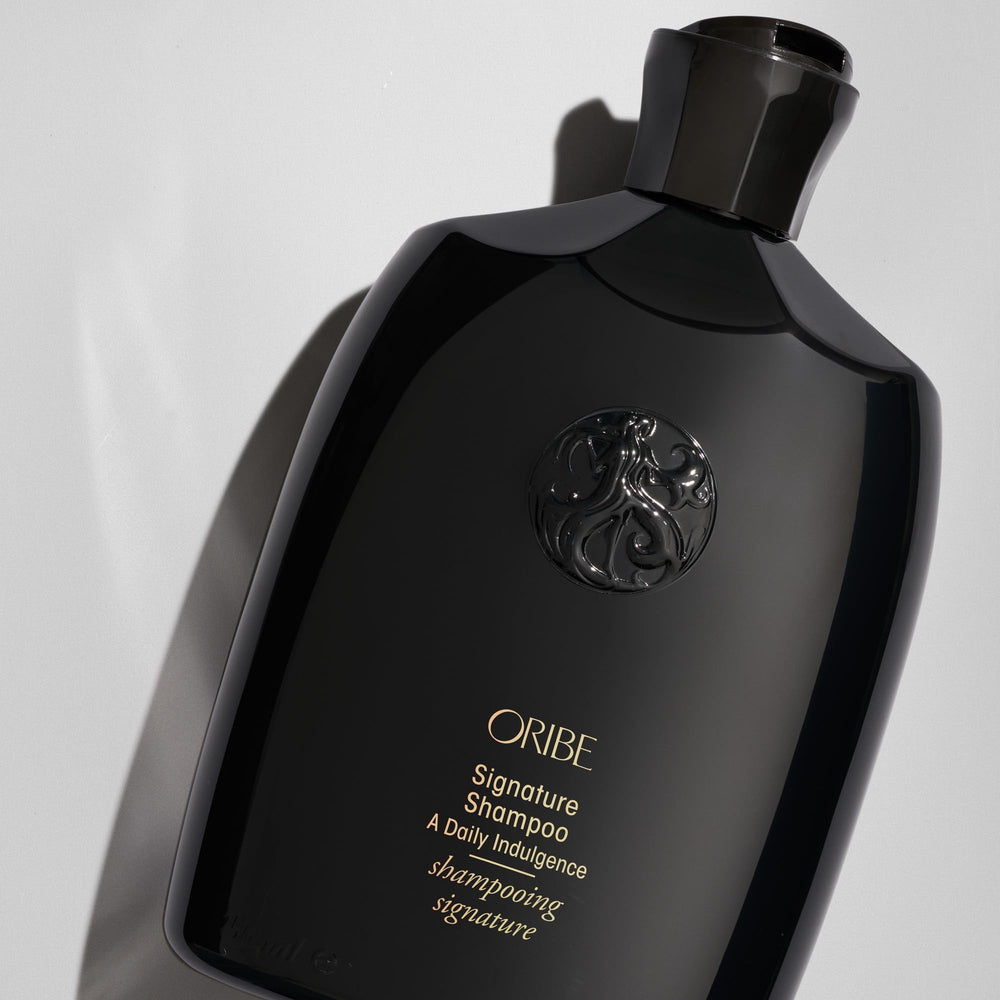 Oribe signature shampoo open cap with foam illustrating easy dispensing benefit