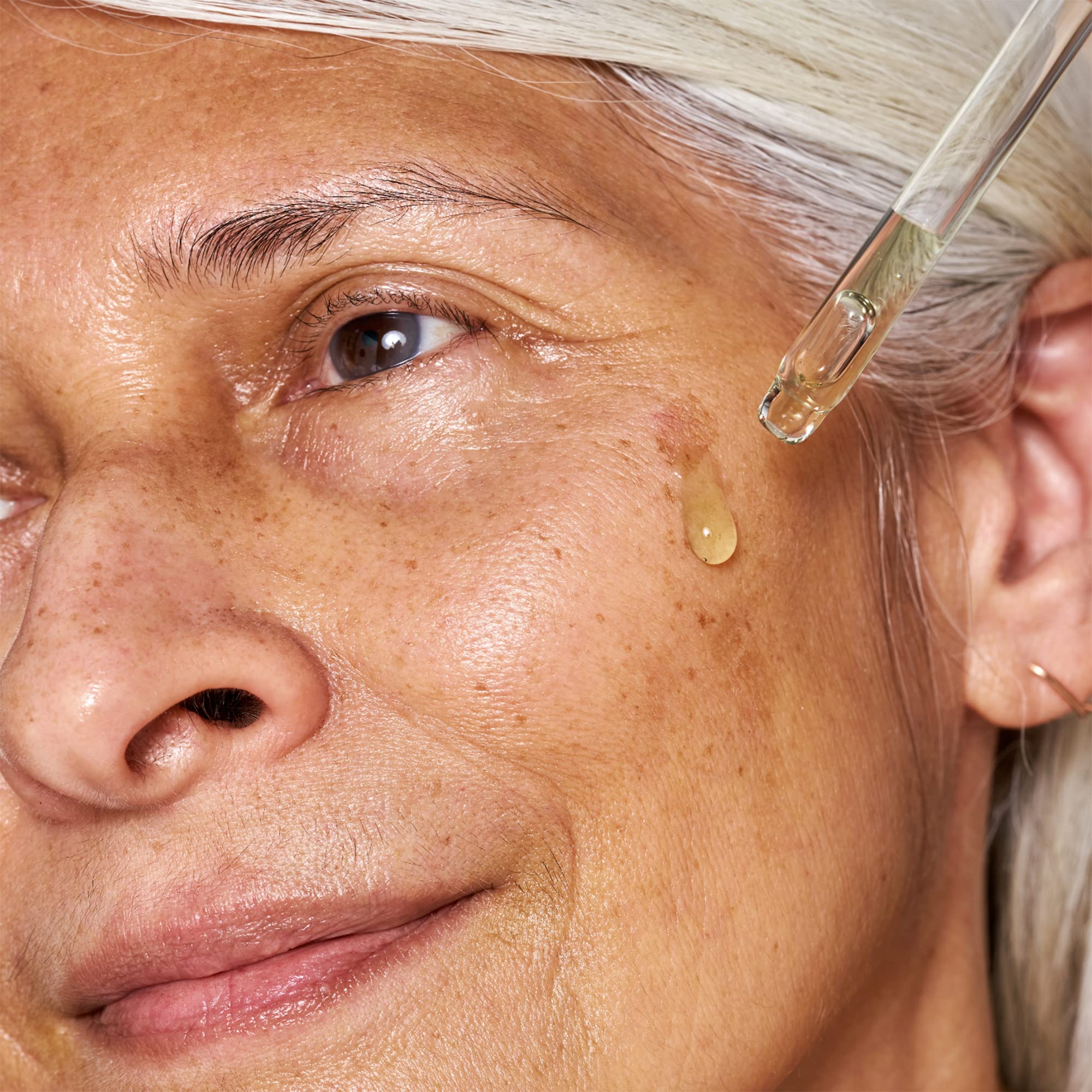 OSEA dispensing a drop of serum on hand demonstrating easy application and layering