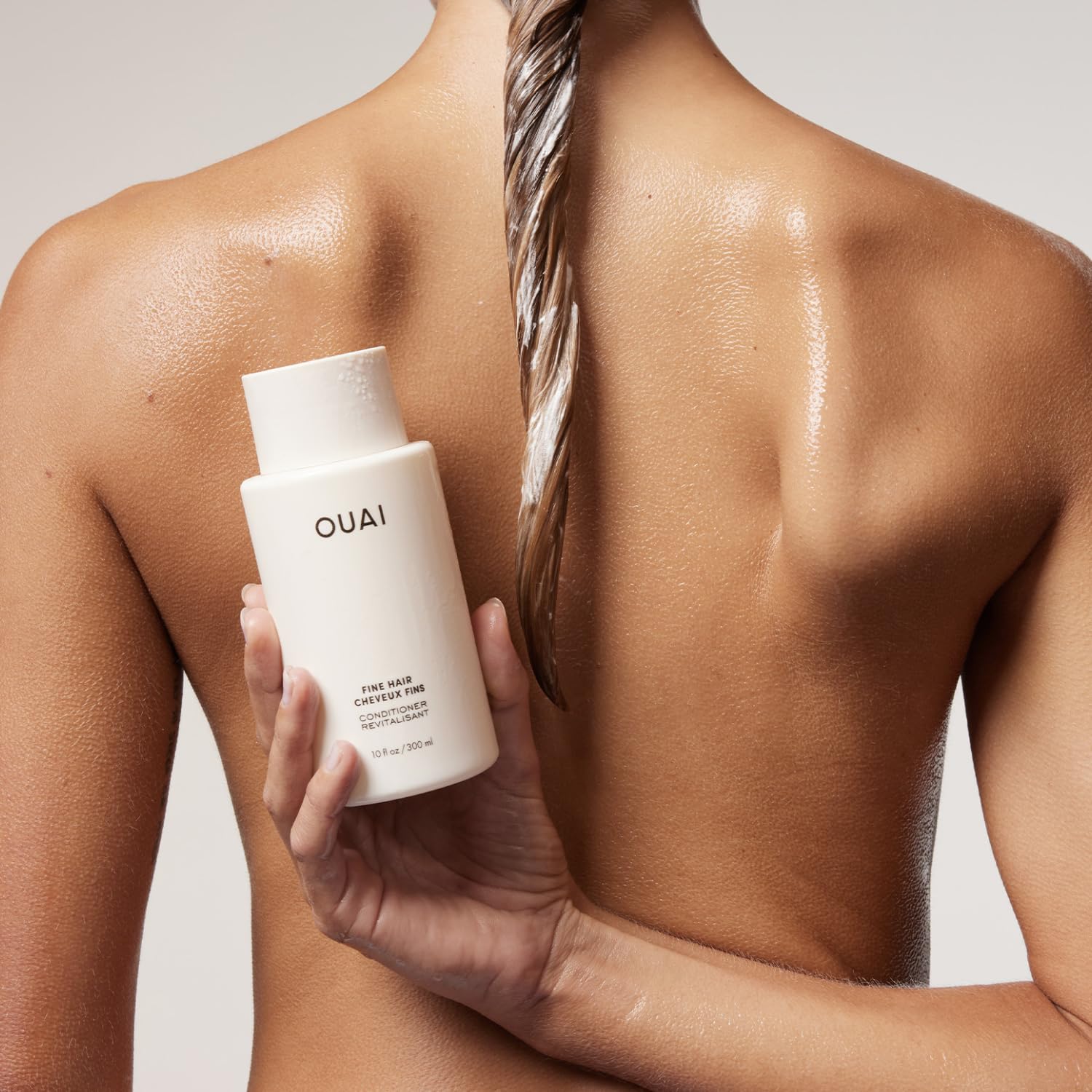 OUAI conditioner being poured to show lightweight texture and easy dispensing