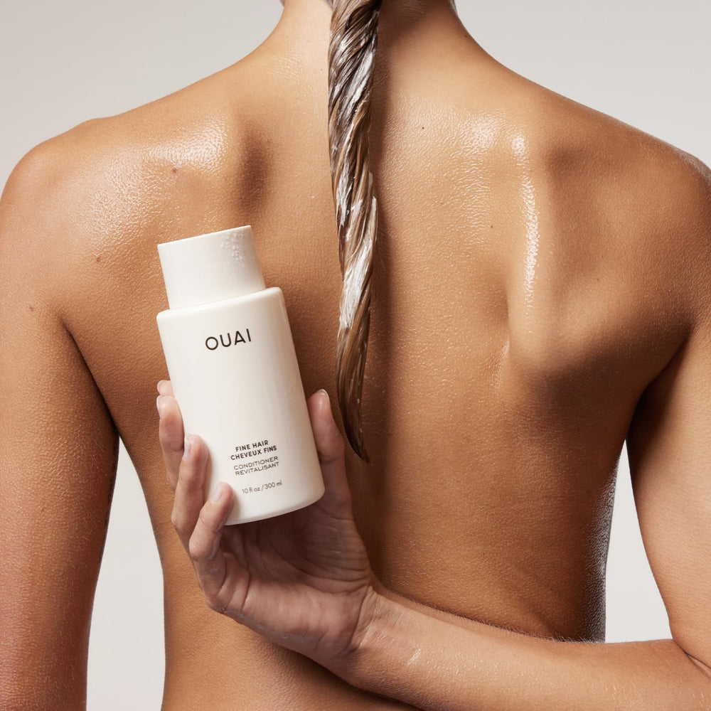 OUAI conditioner being poured to show lightweight texture and easy dispensing