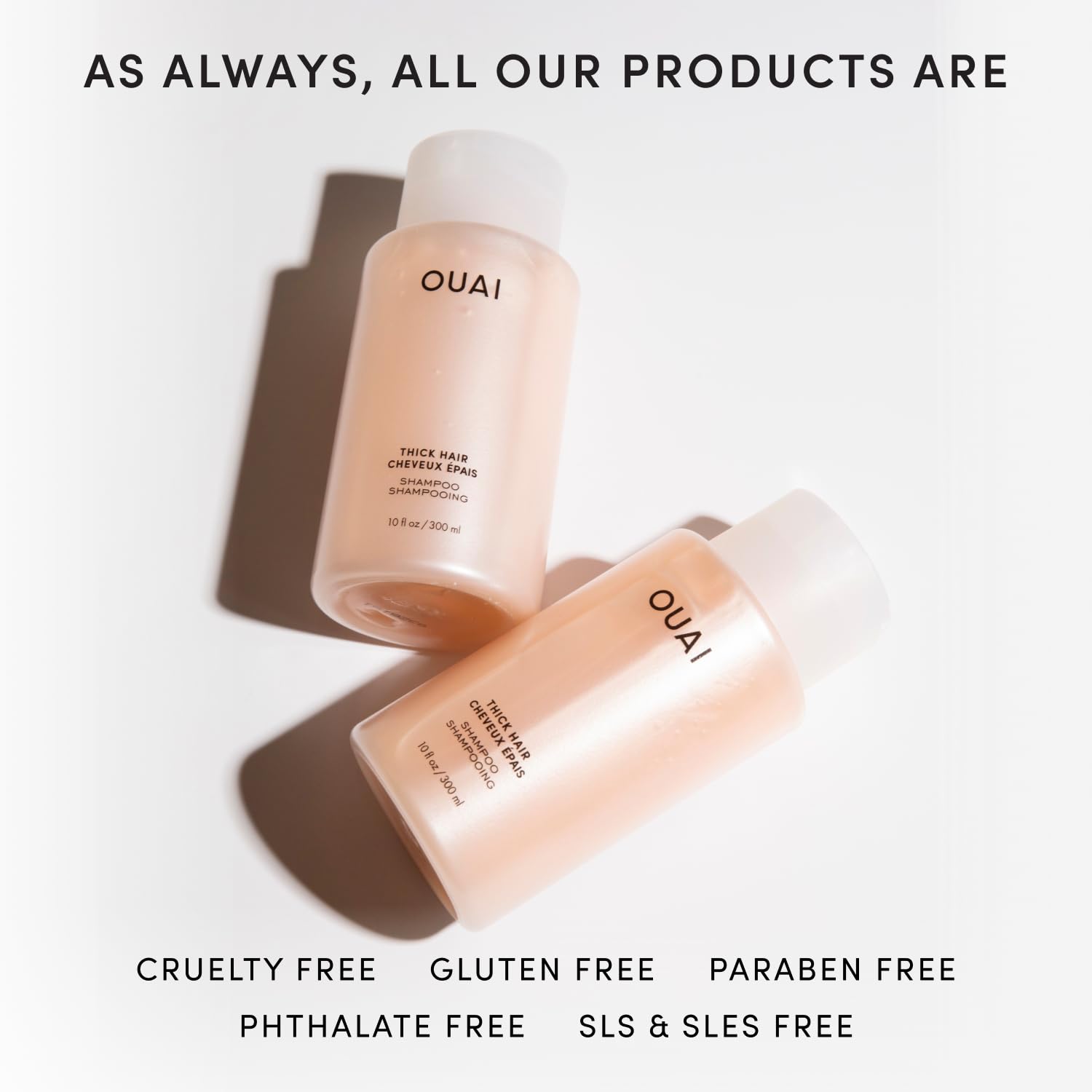 OUAI 32 oz thick shampoo beside a water bottle scale for refill size