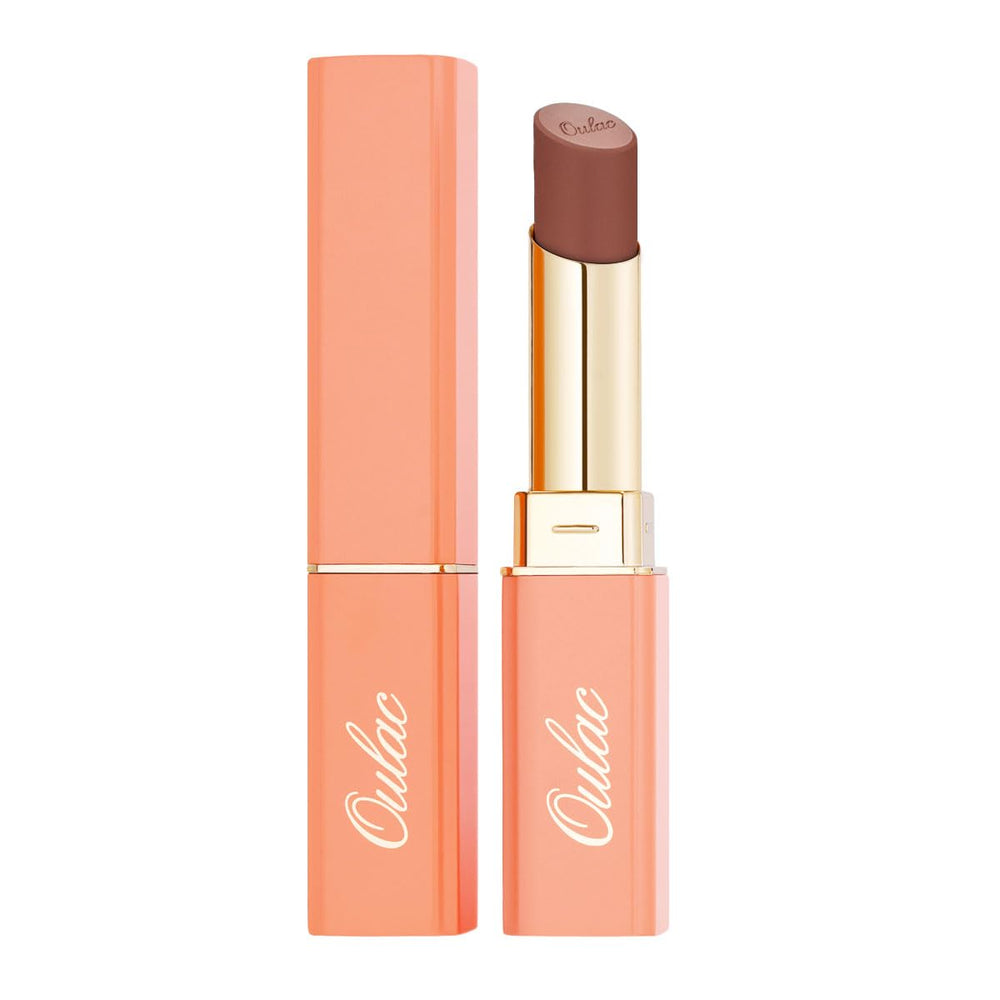 lifestyle flatlay of Oulac lipstick with rose oil bottle highlighting nourishing formula