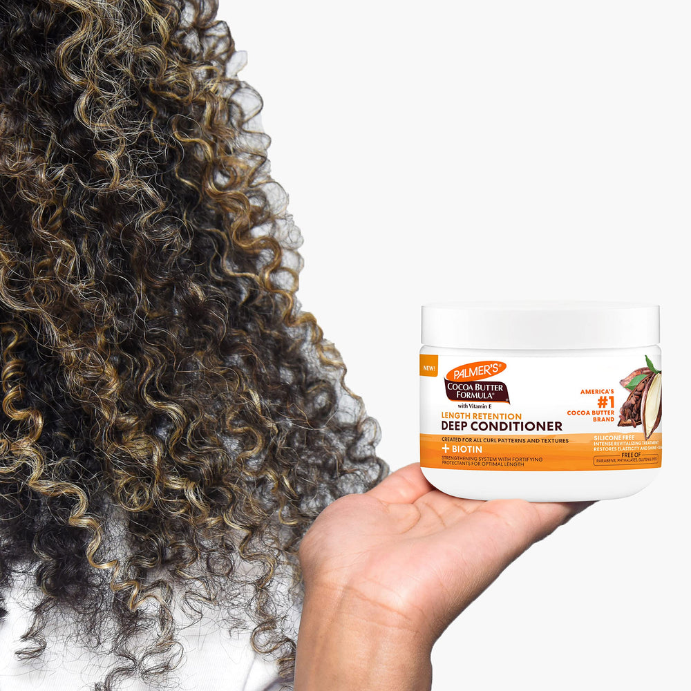 Palmer's being applied to curly hair in shower for deep hydration