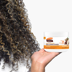 Palmer's being applied to curly hair in shower for deep hydration
