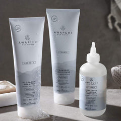 Paul Mitchell bottle beside standard travel items showing 2.5 fl oz scale