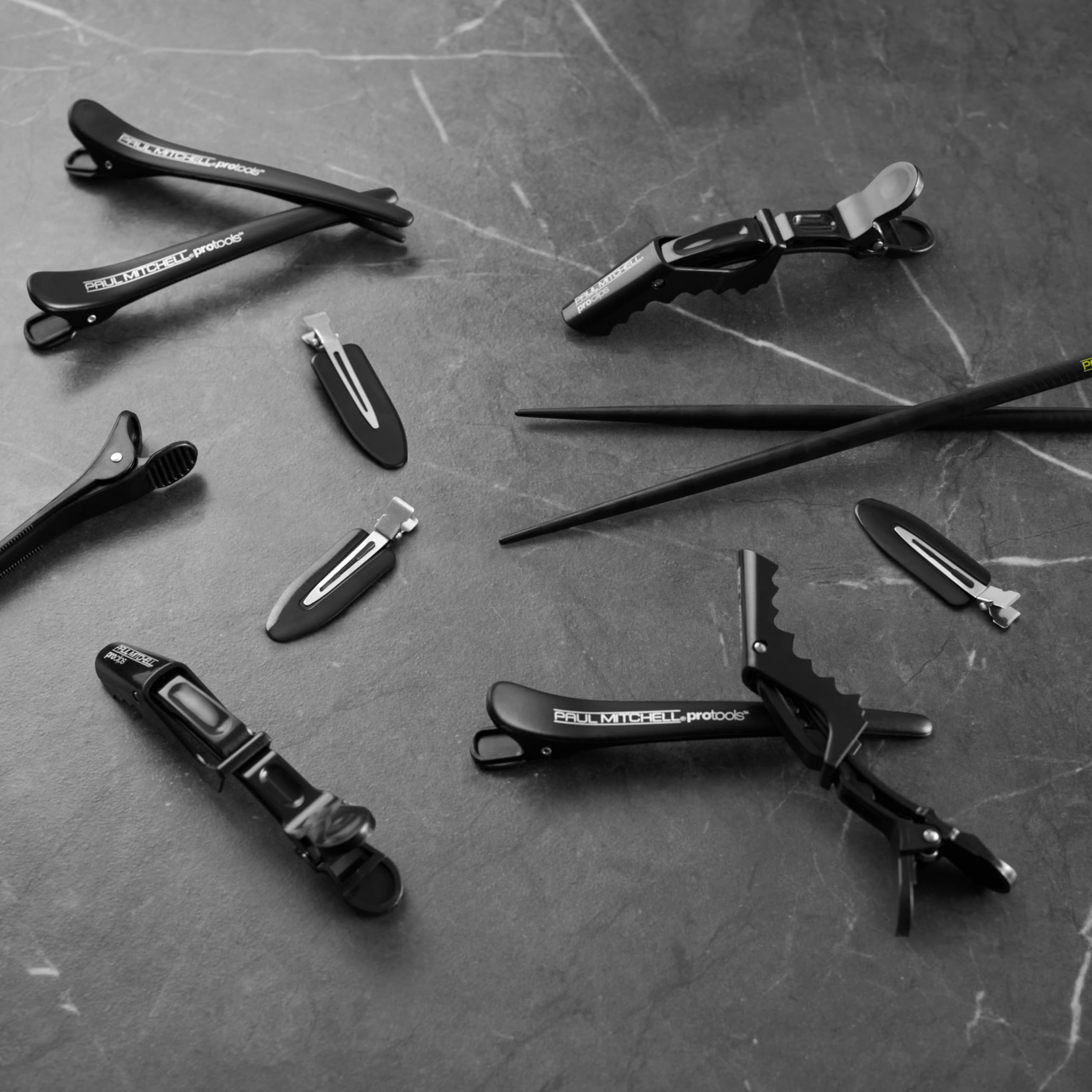 Paul Mitchell clip shown in hand for size scale, easy to carry and store