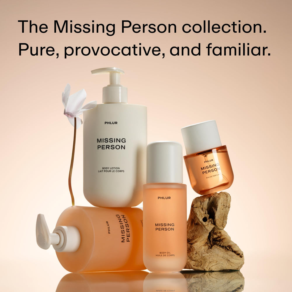 PHLUR on a bedside vanity with candle suggesting intimate, layered fragrance use