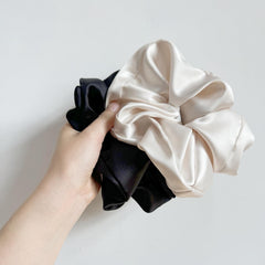 PIDOUDOU scrunchie held in hand to show jumbo scale and secure wrap
