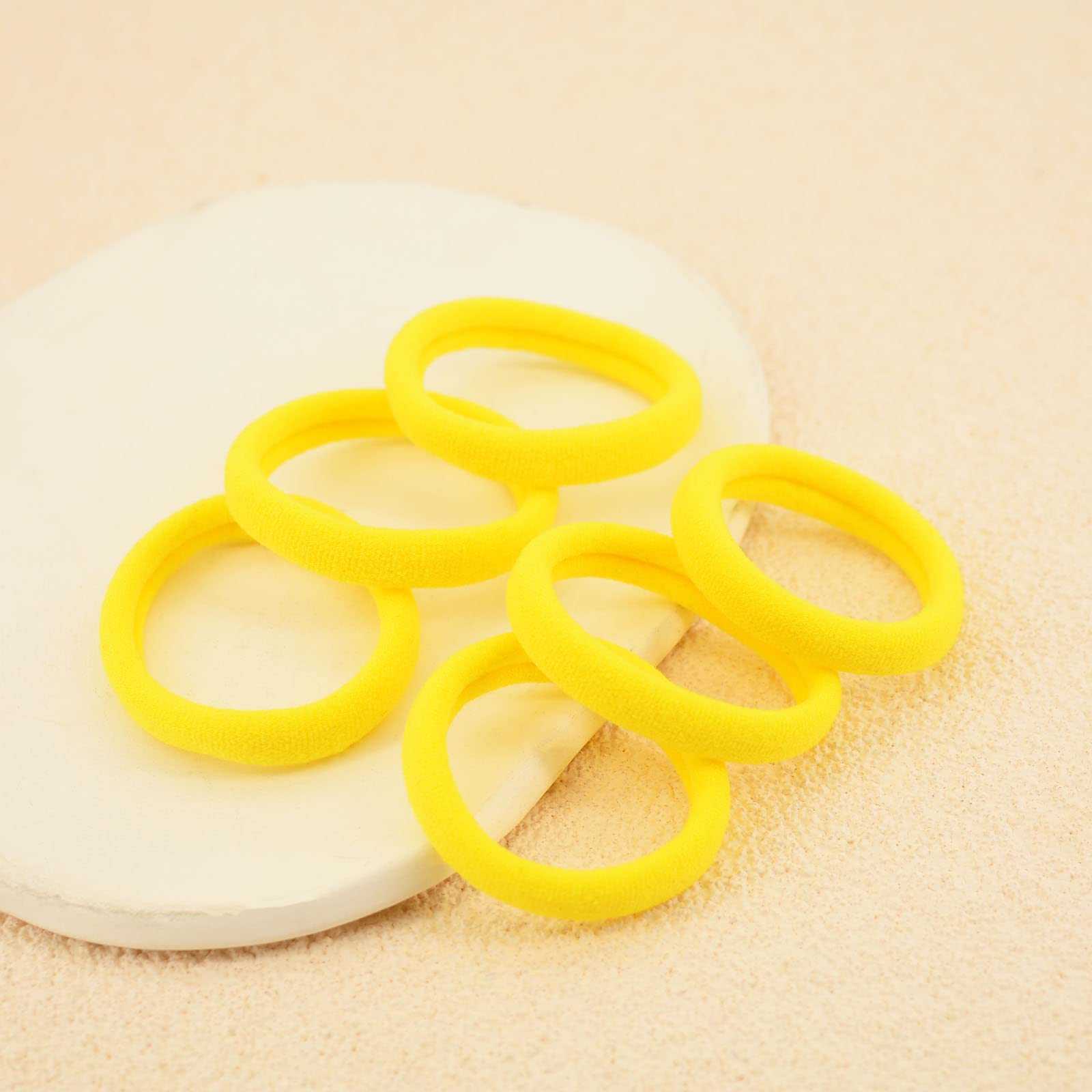 PIDOUDOU hair tie on hand for size reference and easy storage