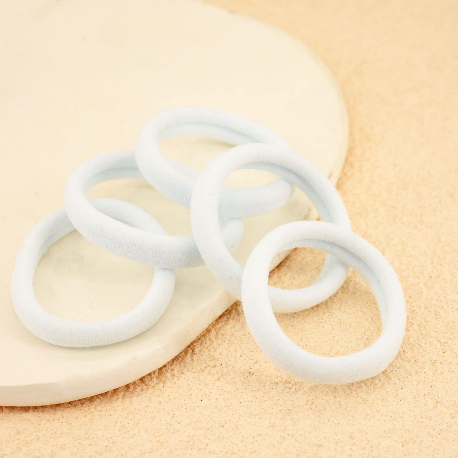 PIDOUDOU hair tie shown in hand to illustrate size and stretch benefit