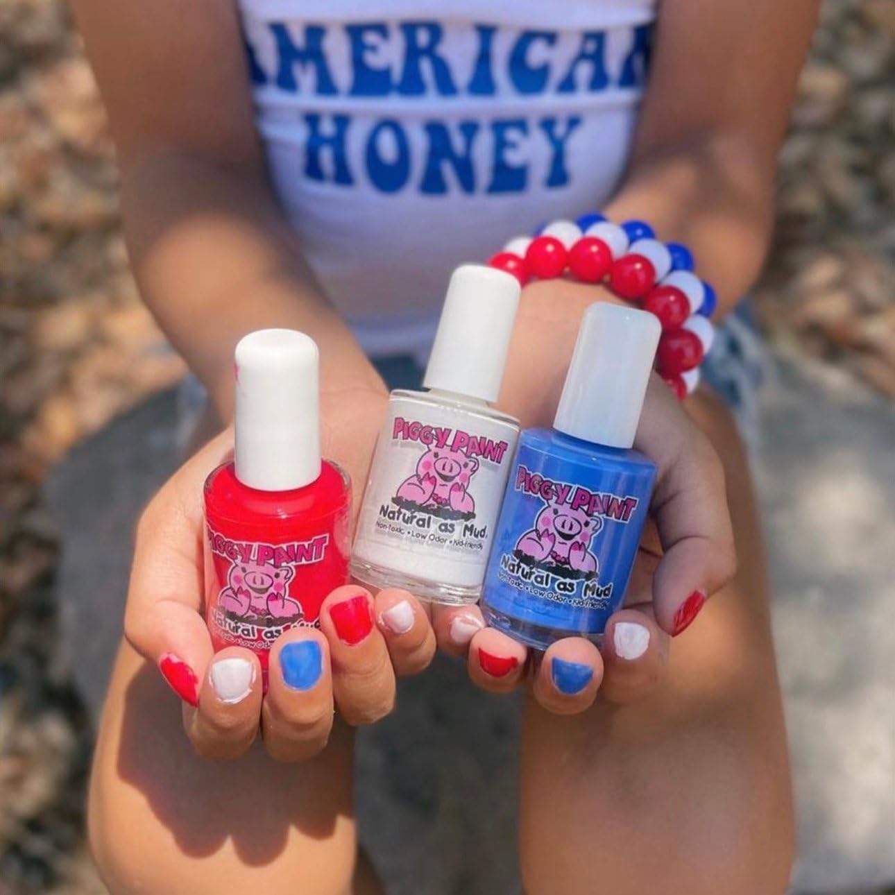 Piggy Paint bottle held in hand for scale showing full-size 0.5 oz convenience