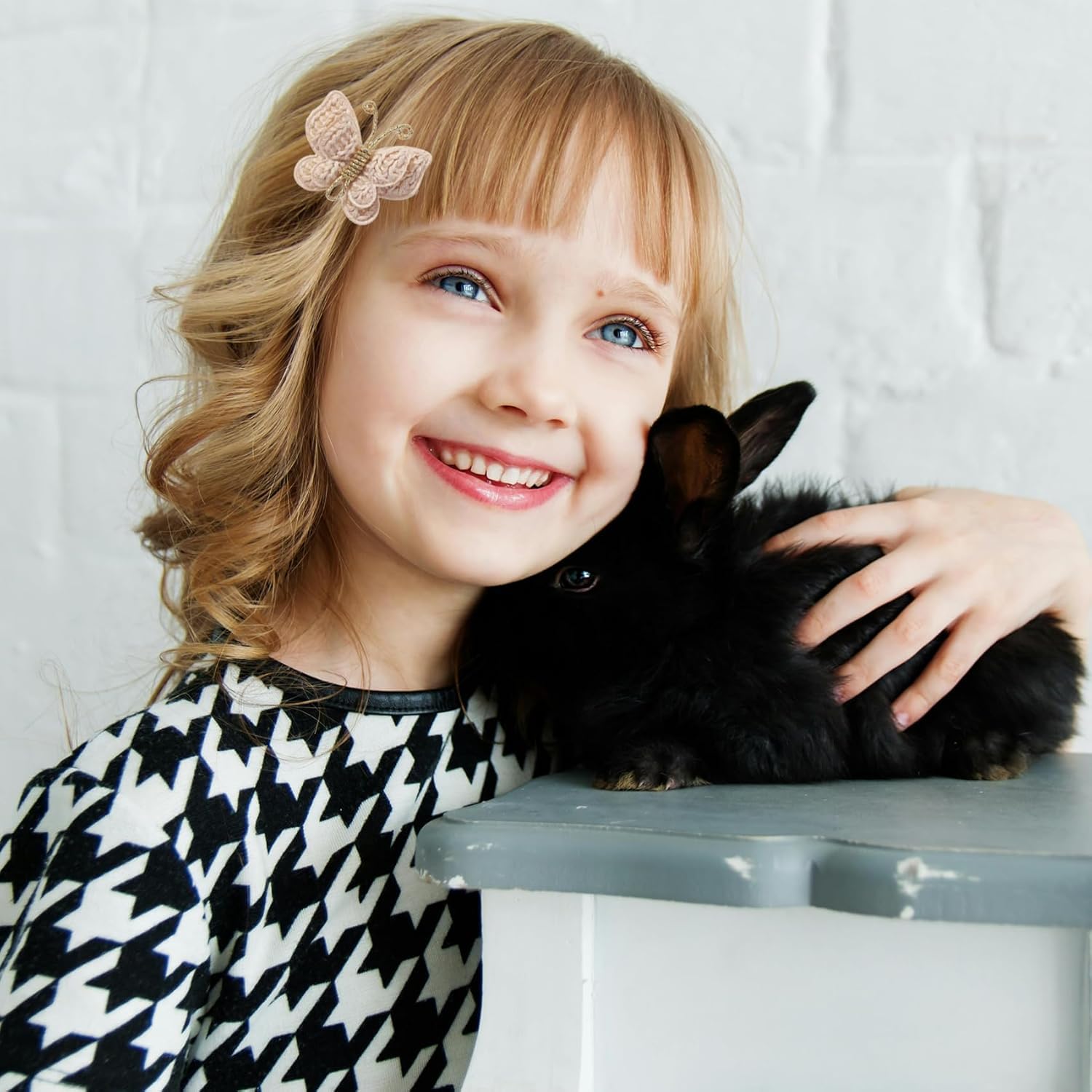 Pinkoriart toddler smiling wearing a butterfly barrette for charming look