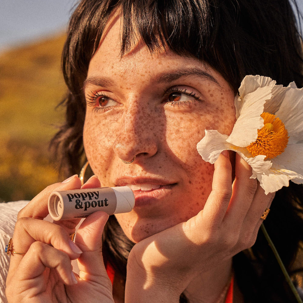 Poppy & Pout coconut oil scoop beside balm showing natural ingredients benefit