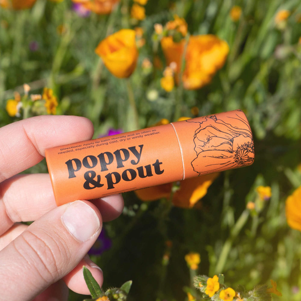 Poppy & Pout lip balm in outdoor winter scene protecting lips from cold