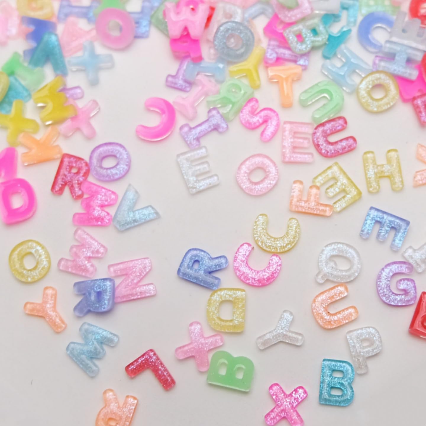Quezadyl tweezers placing a resin letter showing precise application and professional finish benefit