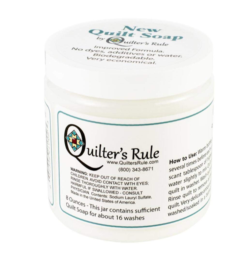 Quilter's Rule quilt soap being used in a washbasin gently cleaning a quilt to preserve fabrics