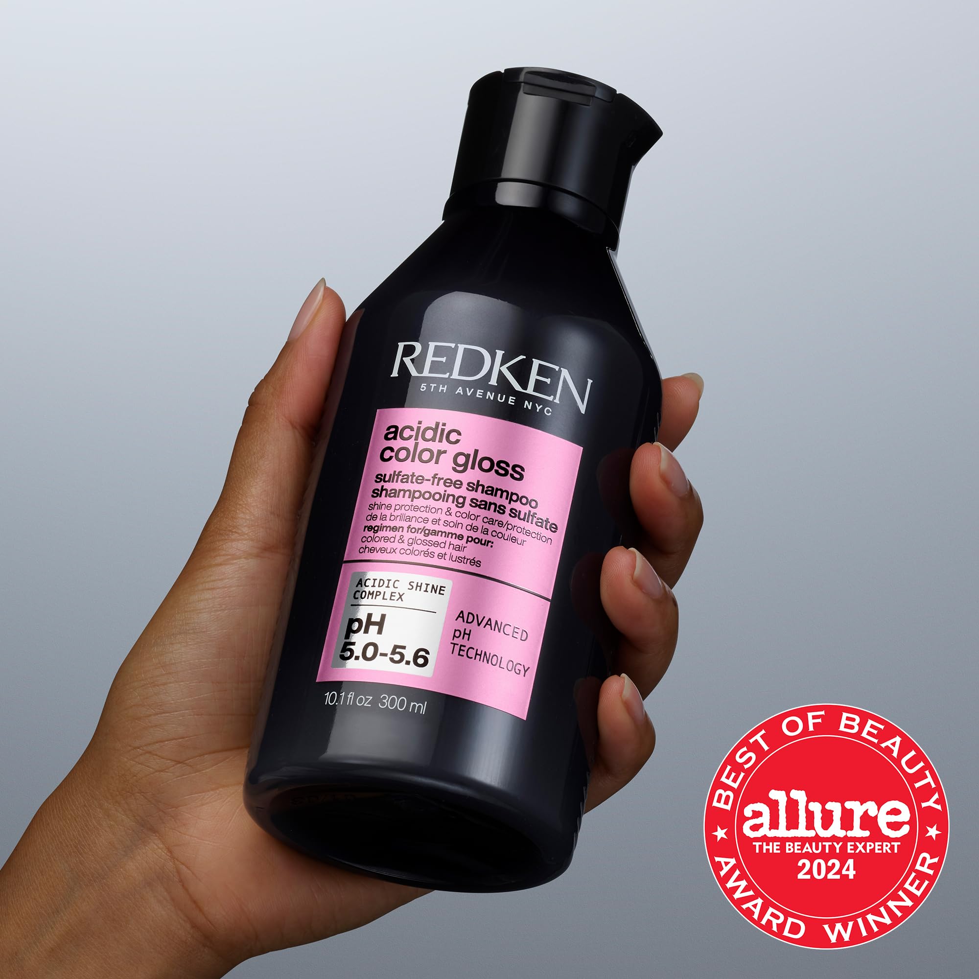 Redken shampoo applied to colored hair under shower showing gentle cleanse benefit