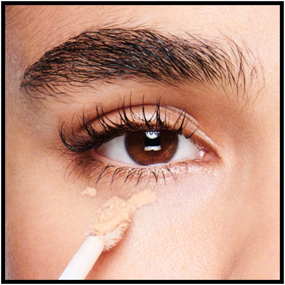 Model applying Revlon concealer under eye demonstrating brightening effect