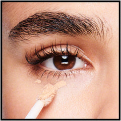 Model applying Revlon concealer under eye demonstrating brightening effect