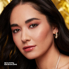 Revlon brow duo next to coin conveying compact travel size and portability