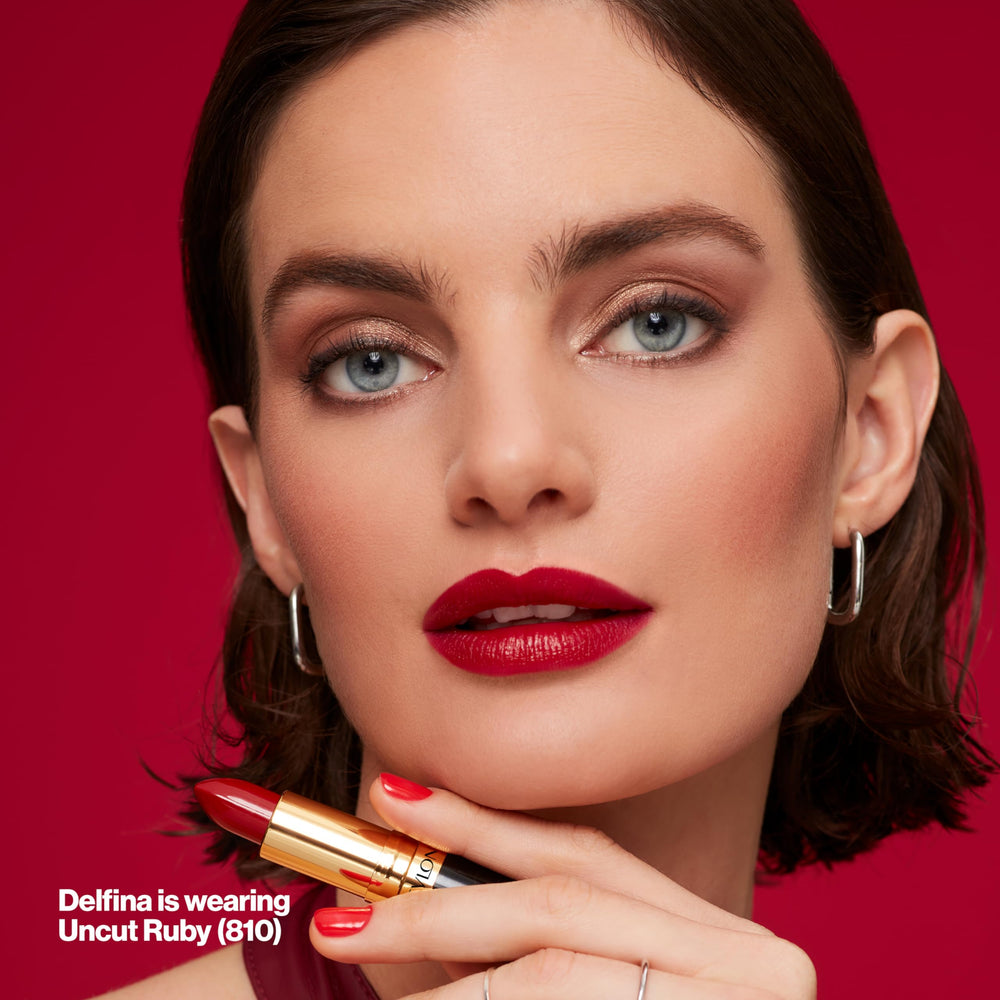 Revlon lipstick next to coin for scale showing compact travel-friendly size