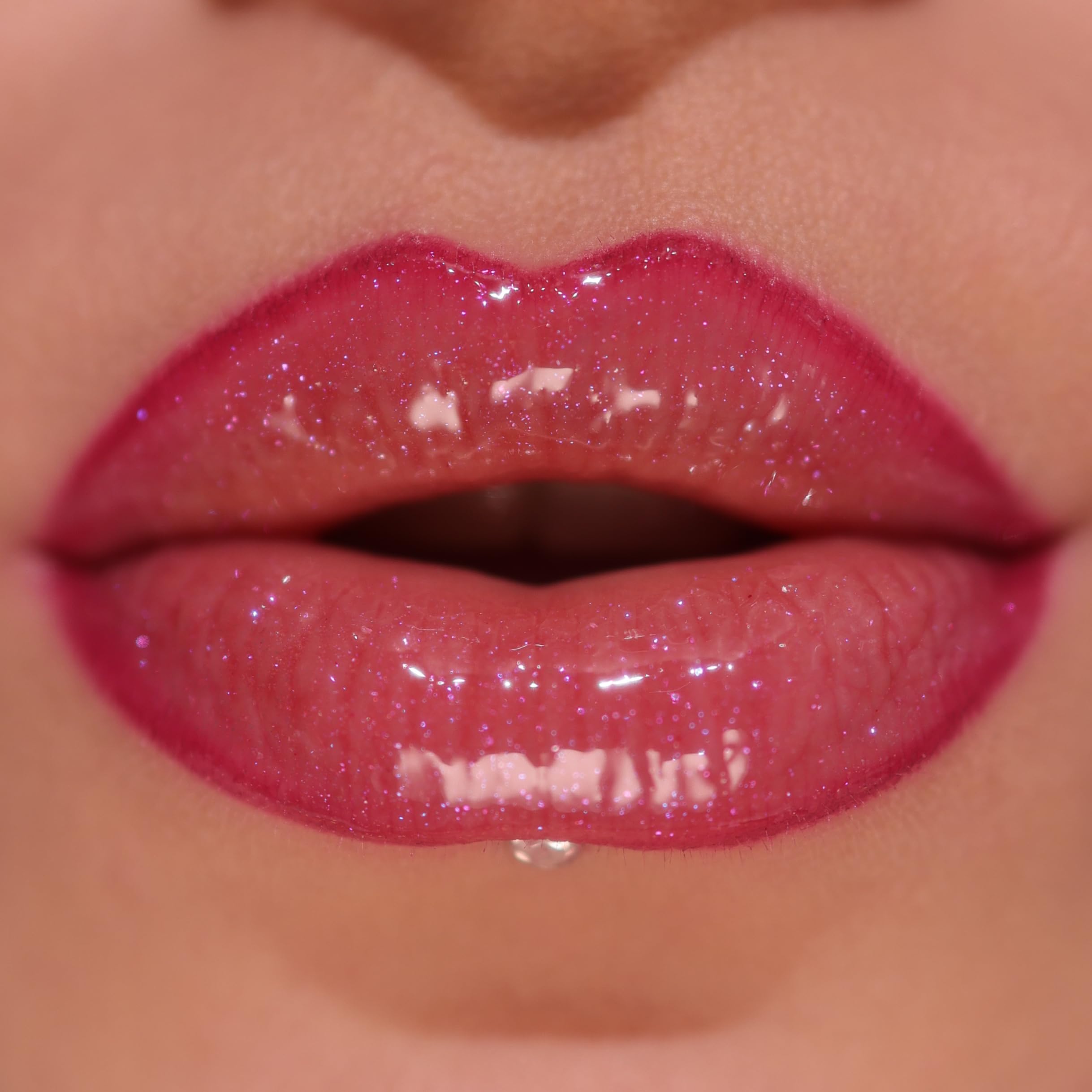 Revolution Pout Bomb on lips in use demonstrating berry shimmer and conditioned look
