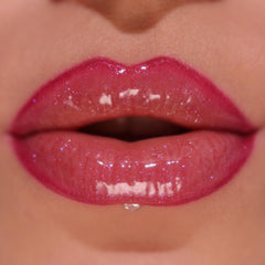 Revolution Pout Bomb on lips in use demonstrating berry shimmer and conditioned look