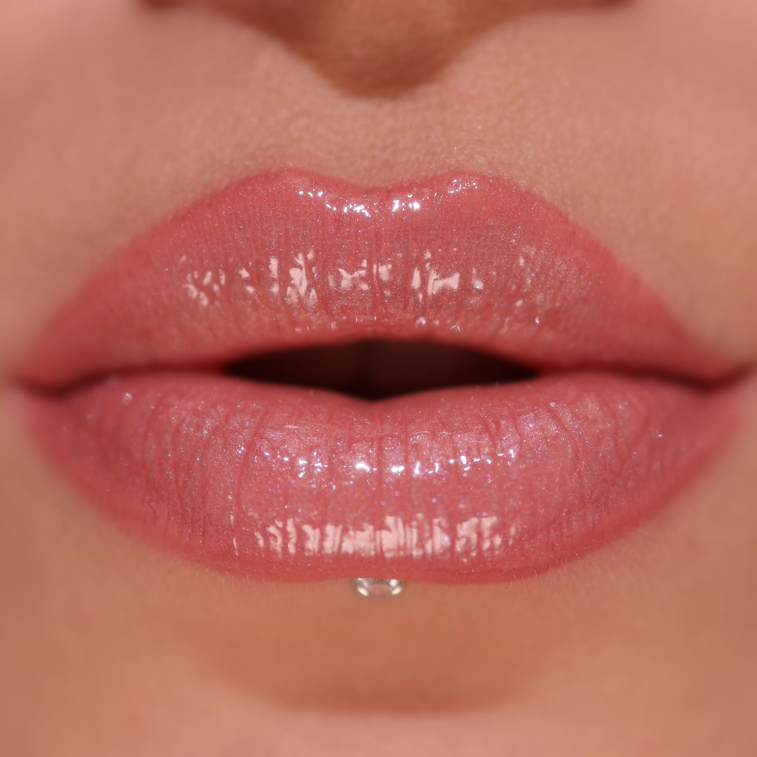Revolution Pout Bomb texture swipe on lips showing shimmer and hydrating finish benefit