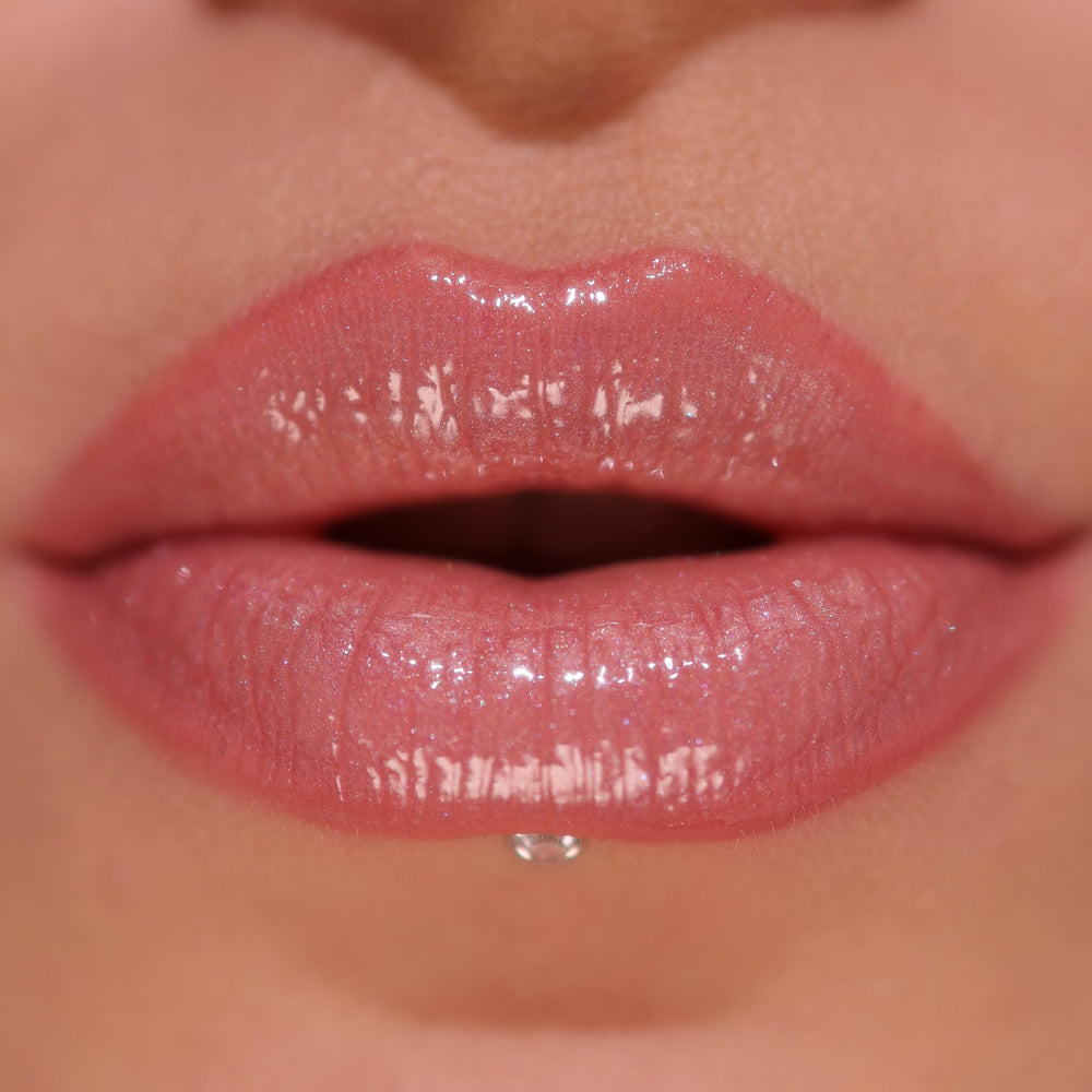 Revolution Pout Bomb texture swipe on lips showing shimmer and hydrating finish benefit